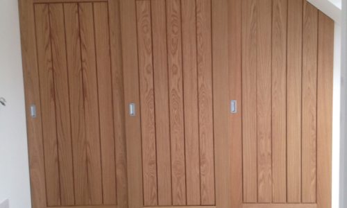 Bespoke built in wardrobe with oak sliding doors.
