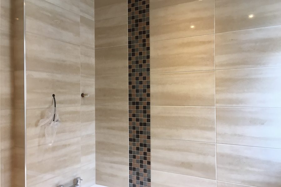 Ceramic tiles with a vertical glass mosaic strip.